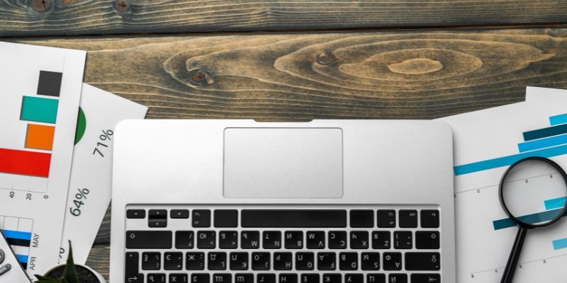 Relatório financeiro e laptop na mesa de negócios